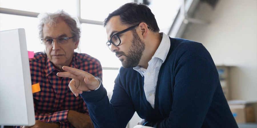 two men looking at a computer