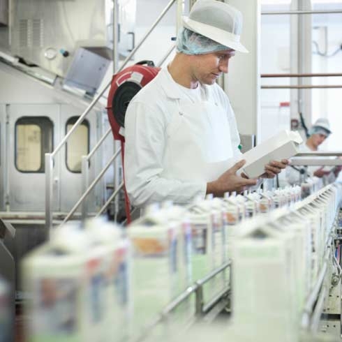 工人在乳制品厂内检查羊奶，食品和饮料，机器控制。