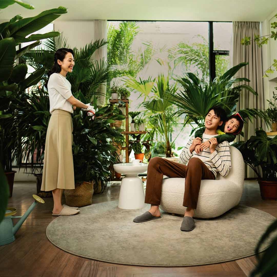 A family in the living room which is full of indoor plants