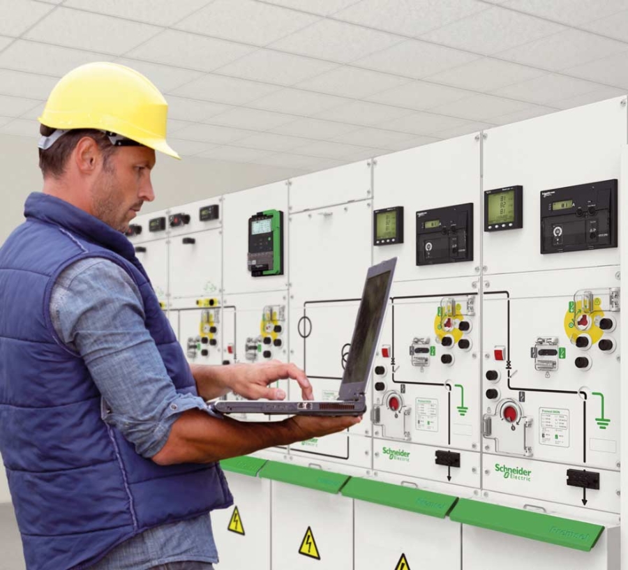 工程师在楼宇自动化控制面板前使用笔记本电脑